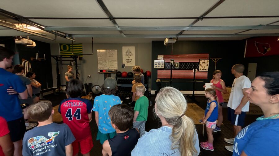 Coach Jess leading a mixed-age group session in the gym